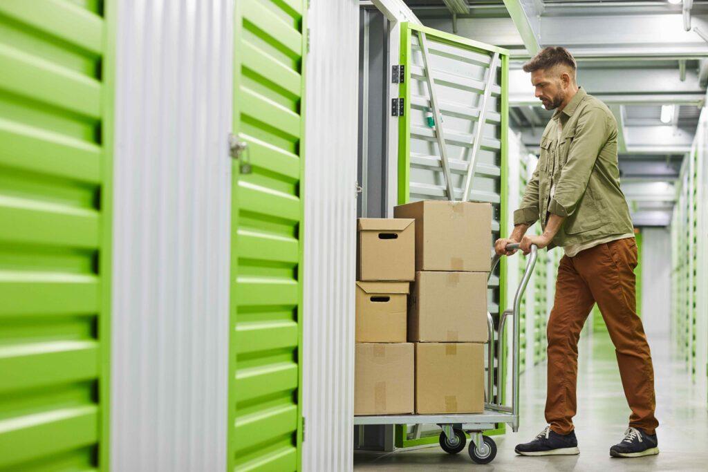 Man pushing boxes into storage unit
