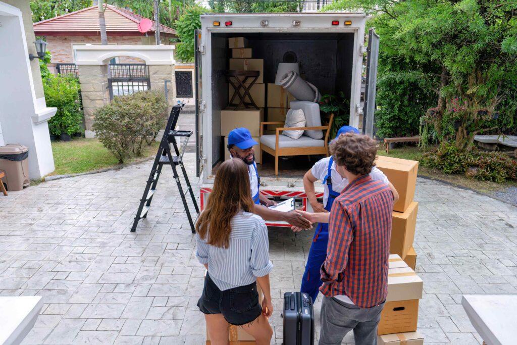 Couple watching men loading a moving van